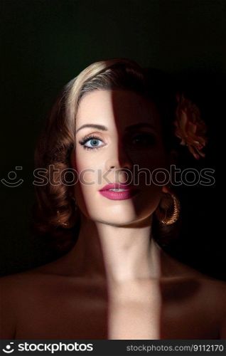 Art shadow light portrait of a young blonde woman with a retro hairstyle. Low light portrait of a young blonde woman with blue eyes and pink lipstick