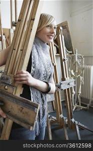 Art student carrying easel into studio