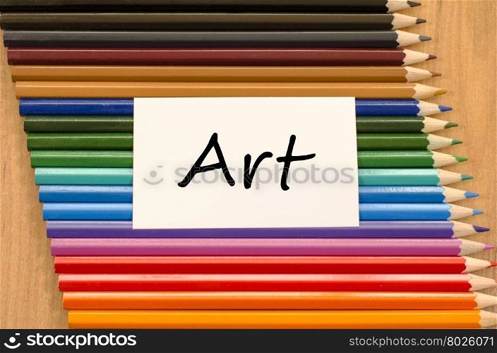 Art text concept and colored pencil on wooden background