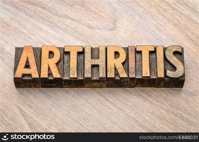 arthritis word abstract in vintage letterpress wood type against grained wooden background