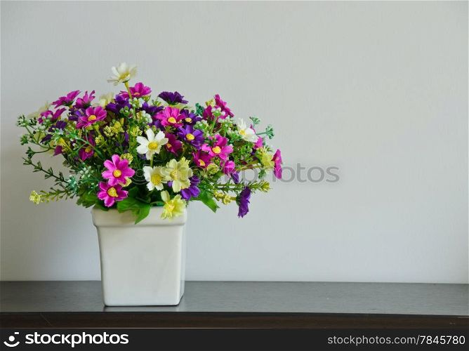 Artificial flower pot on wooden table