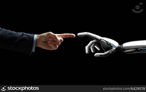 artificial intelligence, future technology and communication concept - robot and human hand connecting fingers on black background. robot and human hand connecting fingers