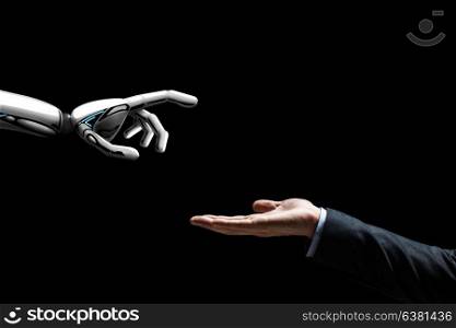 artificial intelligence, future technology and communication concept - robot and human hand on black background. robot and human hand on black background