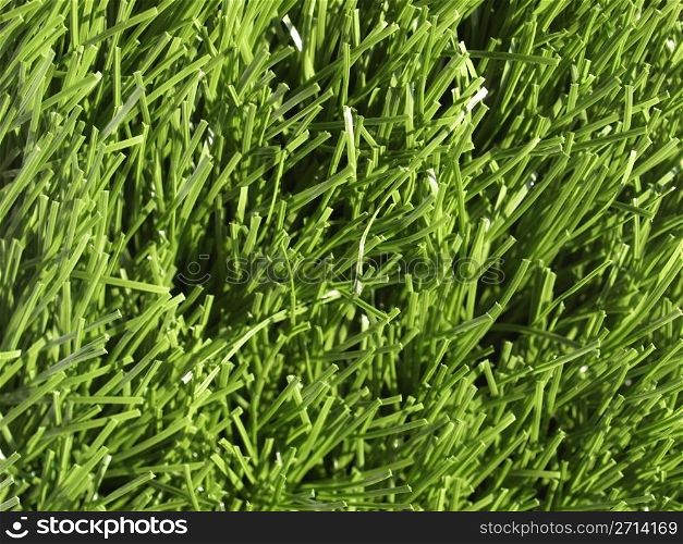 Artificial meadow. Detail of green grass artificial lawn meadow, useful as a background