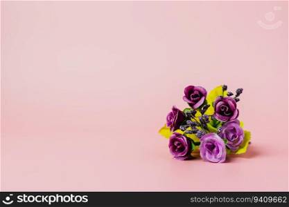 Artificial purple rose bouquet on pink background for love and Valentine’s day concep