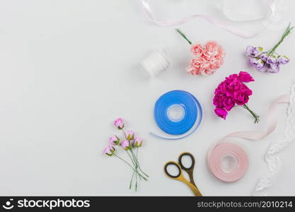 artificial roses scissor with blue pink ribbon white background