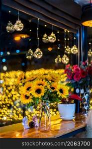 artificial sunflower in glass vase for decoration for Christmas decoration lights in the shape of on Bokeh background Decoration During Christmas and New Year.