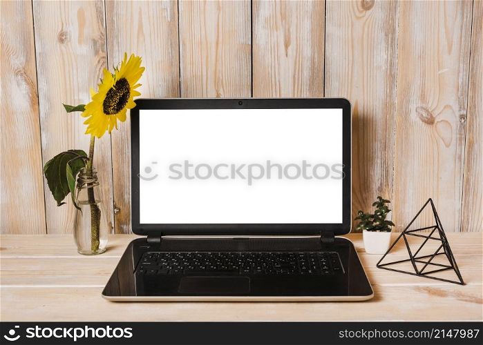 artificial sunflower vase with laptop wooden table