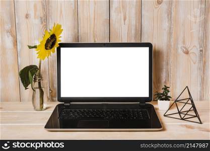 artificial sunflower vase with laptop wooden table