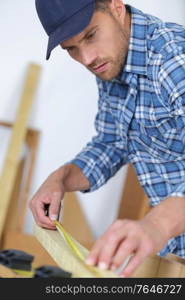 artisan carpenter measuring wood frame