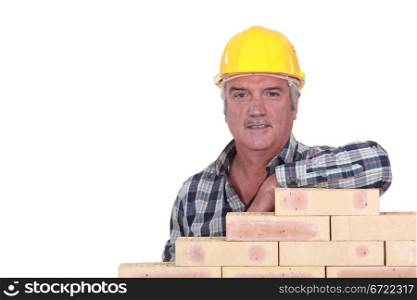 Artisan leaning on stack of bricks