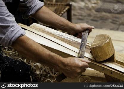Artisan sanding and shaping wood, detail of craftsman's work