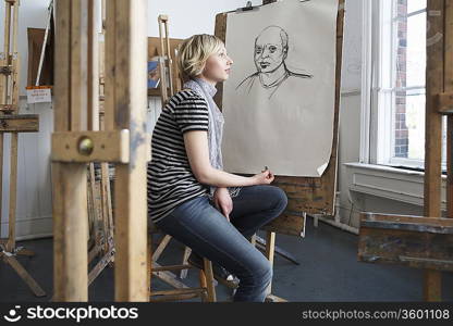 Artist drawing charcoal portrait in studio