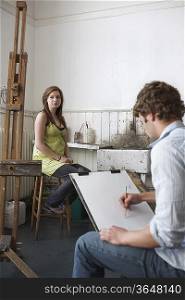 Artist drawing, model posing, in studio