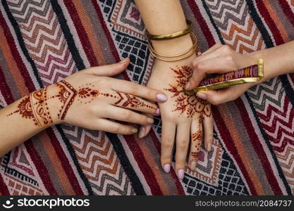 artist making mehndi womans hand bright table