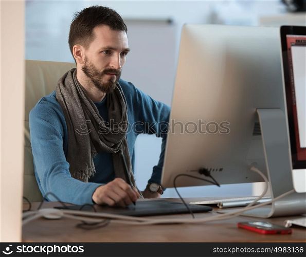 Artist or designer drawing something on graphic tablet at the office