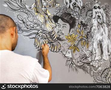 Artist painting free styles acrylic color on gray wall background with abstract pattern ,animal, dog and unidentified portrait of man