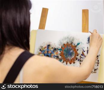 Artist painting on an easel, OTS shot