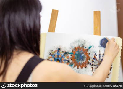 Artist painting on an easel, OTS shot