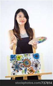 Artist standing behind painting holding palette and brush