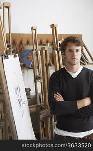 Artist standing by charcoal portrait in studio