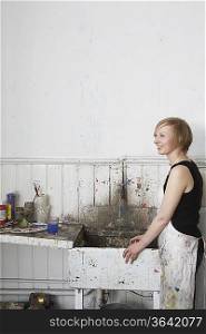 Artist standing by sink in studio