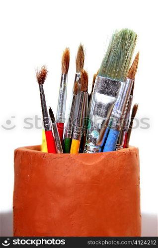 Artist used brushes clay pot isolated on white