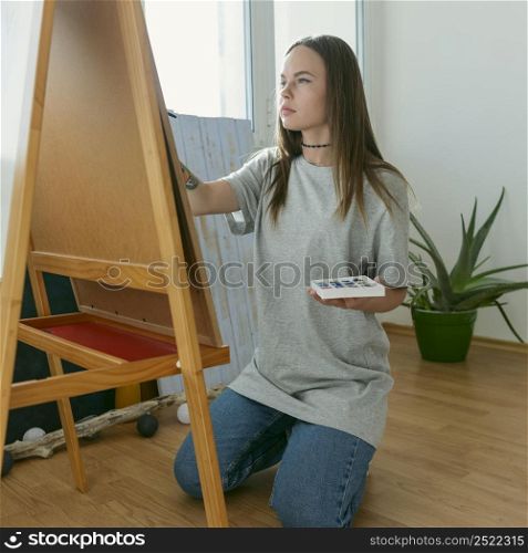 artist woman painting canvas side view