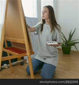 artist woman painting canvas side view