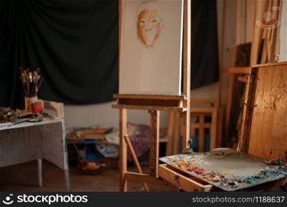 Artist workshop interior, painter studio, nobody. Painting supplies. Color palette, brushes and easel, drawing tools and equipment