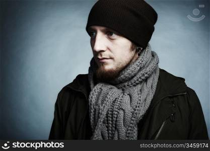 Artistic dark portrait of the young beautiful man in a cap and a dark jacket