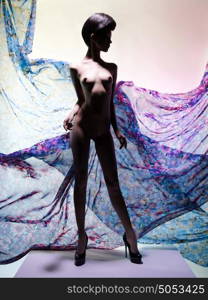 Artistic fashion studio photo of nude elegant woman surrounded by flowing draperies. Perfect body. Beauty and health