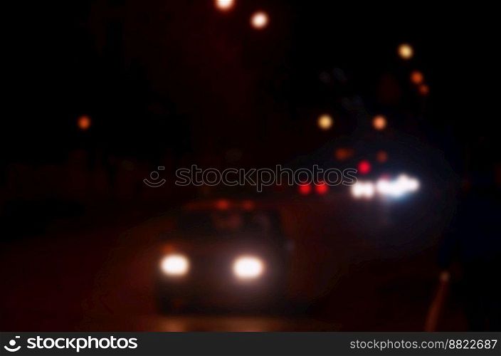 Artistic style - Defocused urban abstract texture, blurred background with bokeh of city lights from car on street at night, vintage or retro color tone. Blurred landscape of night city