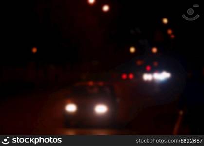 Artistic style - Defocused urban abstract texture, blurred background with bokeh of city lights from car on street at night, vintage or retro color tone. Blurred landscape of night city