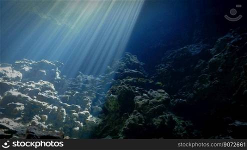 Artistic underwater photography of rays of sunlight inside a cave