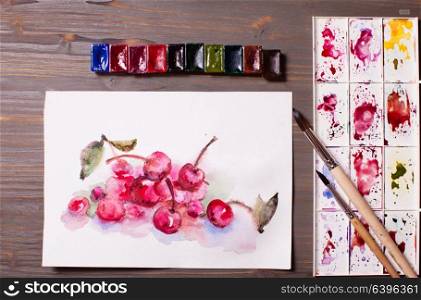 Artwork, watercolor painting cherries with drawing tools on a wooden table. Watercolor painting cherries