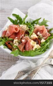 Arugula salad, prosciutto with sun-dried tomatoes, slices of mozzarella, capers, seasoned with olive butter and parmesan. A dish for those who monitor their health