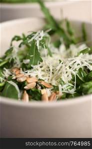 Arugula salad with sunflower kernels and sprinkled with grated parmesan