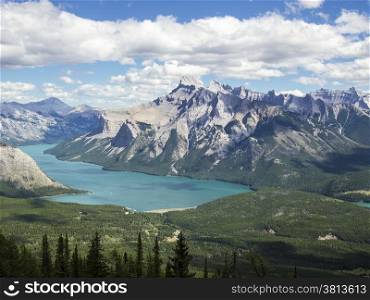 As seen from the top of the CLevel Cirque trail, Lake Minnewanka in the Banff National Park in the Canadian Rocky Mountains glows with a soft blue color as the light is reflected from glacial flour and silt.