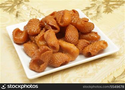 Asabe zeinab or Zeinabs fingers on a plate. This Middle Eastern sweet treat made of a semolina yeast dough, formed into this shape and coated in syrup. It is particularly popular in Ramadan.
