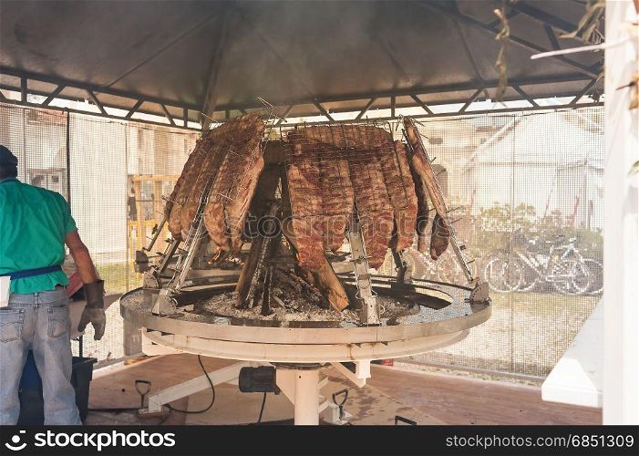 Asado, traditional barbecue dish in Argentina. Roasted meat of beef cooked on a vertical grills placed around fire