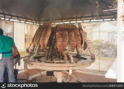 Asado, traditional barbecue dish in Argentina. Roasted meat of beef cooked on a vertical grills placed around fire