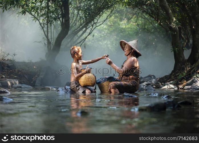 Asaia old lady and child boy fishing on river stream nature in countryside of living life farmer rural / senior woman grandmother and grandchild