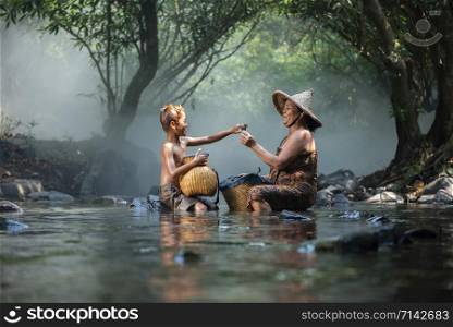 Asaia old lady and child boy fishing on river stream nature in countryside of living life farmer rural / senior woman grandmother and grandchild