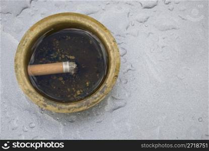 ashtray filled with water and a cigarette swimming within