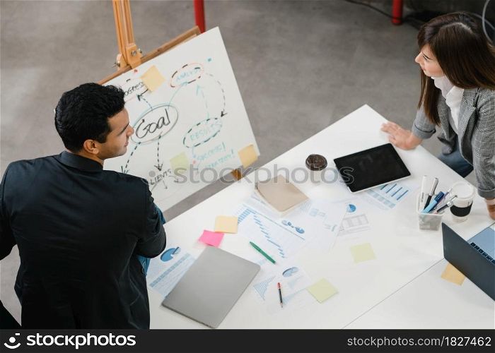 Asia businessmen and businesswomen meeting brainstorming ideas conducting business presentation project colleagues working together plan success strategy enjoy teamwork in small modern office.