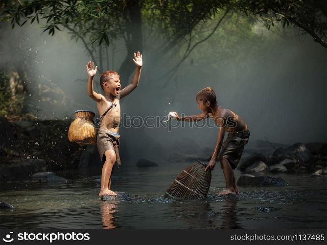 Asia child life laugh fisherman on river stream / The boy friend happy funny laughing and smile boy Fishing fish in hand at countryside of living life kids rural people