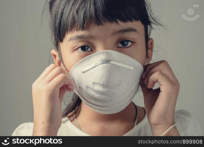 Asia child who have to wear a dust safety mask, Because the air is polluted and may cause her illness