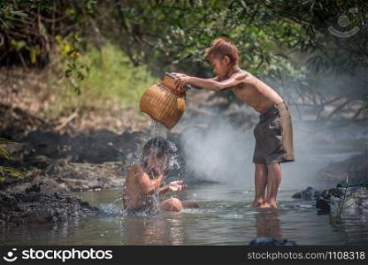 Asia children on river / The boy friend happy funny playing in the water stream in countryside of living life kids farmer rural people