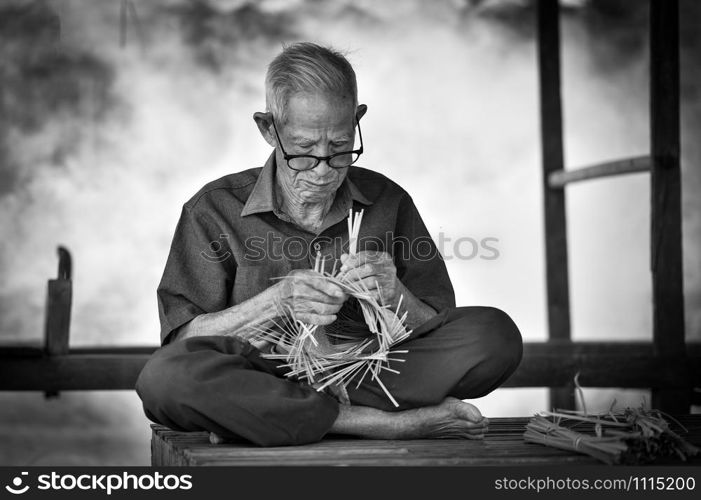 Asia life old man uncle grandfather working in home / Man elderly serious living in the countryside of life rural people in thailand weave bamboo basket crafts